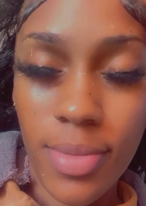 Close-up portrait of a woman with closed eyes and pink lips, wearing subtle eye makeup